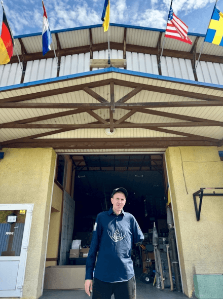 Taras is standing in front of a yellow building.