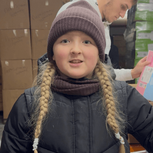 Eleonora volunteers at a humanitarian aid warehouse in Ukraine, helping organize and distribute donated supplies for families and children in need.