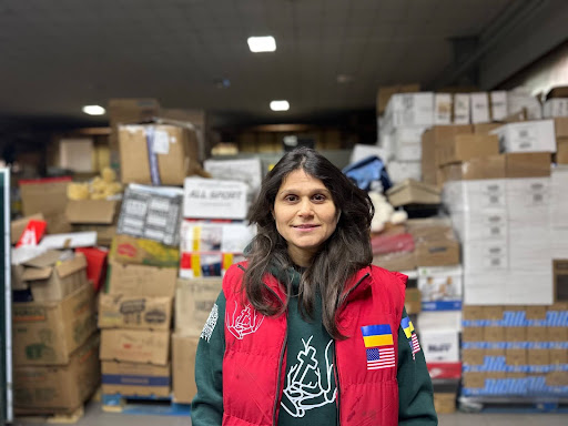 Katya, humanitarian volunteer with Family of Christ International, standing in warehouse preparing aid for families in Ukraine