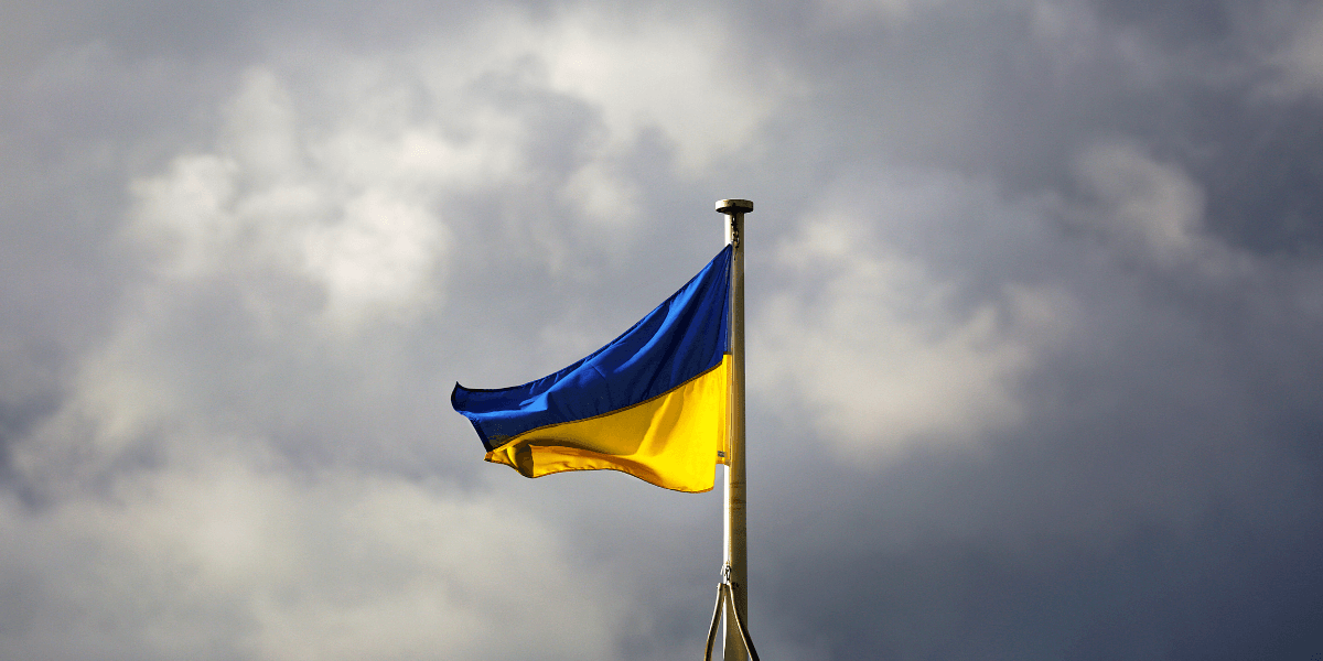 Flag of the Ukraine set in front of a cloudy sky.