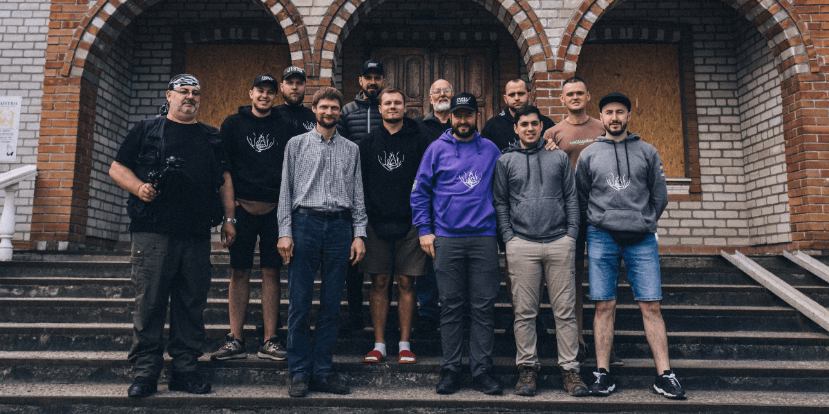 A group of Family of Christ International volunteers standing in front of a church.