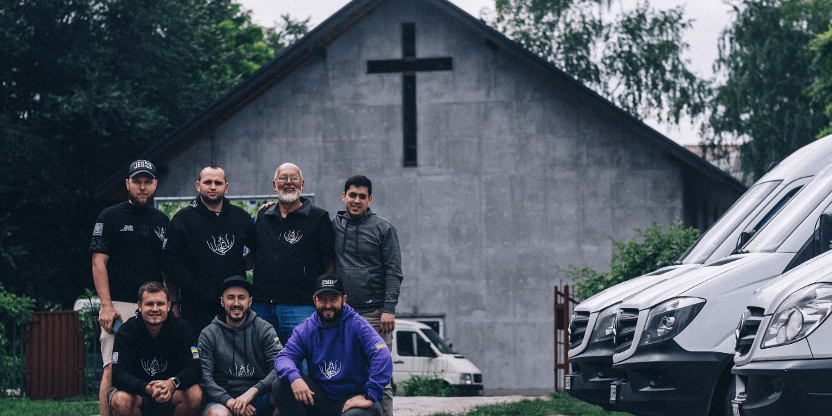A group of Family of Christ International volunteers standing in front of a church. 